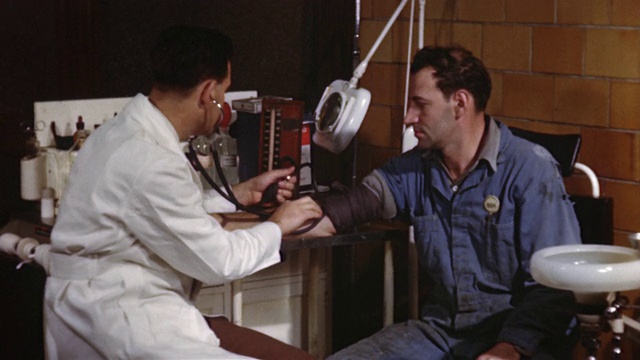 1955年，MS医生给一名男子手臂包扎血压带并测量血压/美国视频下载