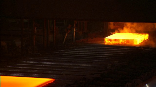 在中国北京的钢铁厂，红色热钢板在输送机上传递视频下载