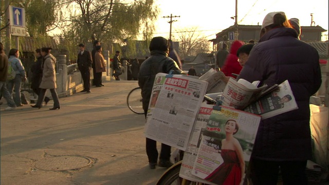 中国北京后海，街上的交通和卖报纸的人在金鼎桥附近视频下载