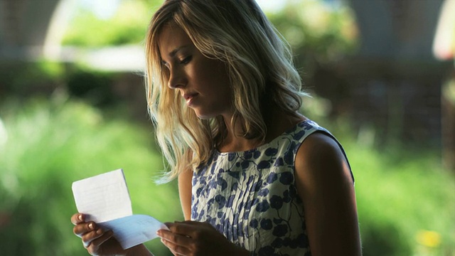 SLO MO MS TU年轻女子阅读信在夏季花园，Lehi，犹他州，美国视频素材