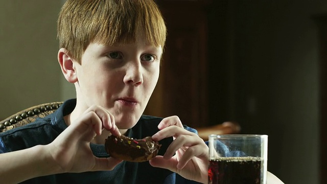 cuboy(10-11)坐在桌子上，吃着可乐和甜甜圈，美国犹他州的American Fork视频素材
