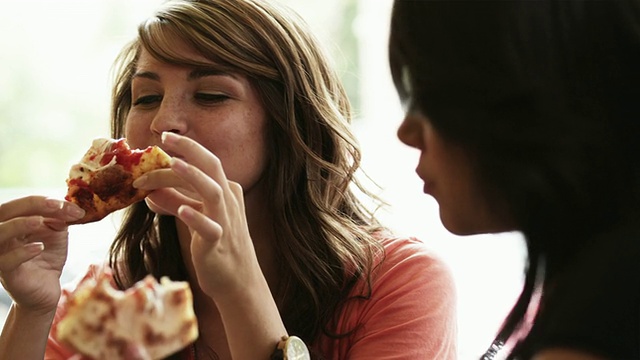 两名年轻女子在美国犹他州普罗沃的餐厅吃披萨视频素材