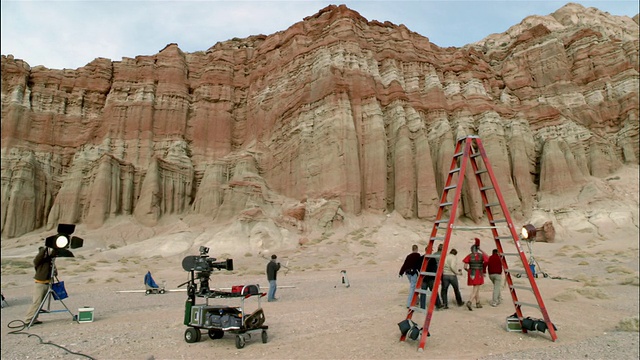 多莉拍摄了电影导演走出他的拖车，当他走向片场/红石峡谷国家公园时，被服装人员和其他人接近视频下载