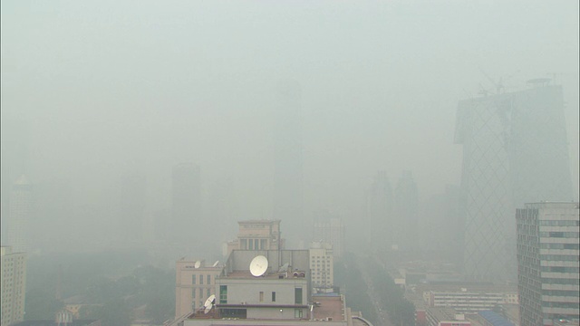 在厚厚的灰色雾霾中，中国北京，城市天际线几乎看不见视频下载