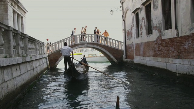 意大利威尼斯运河上的WS POV贡多拉在建筑物之间穿梭视频素材