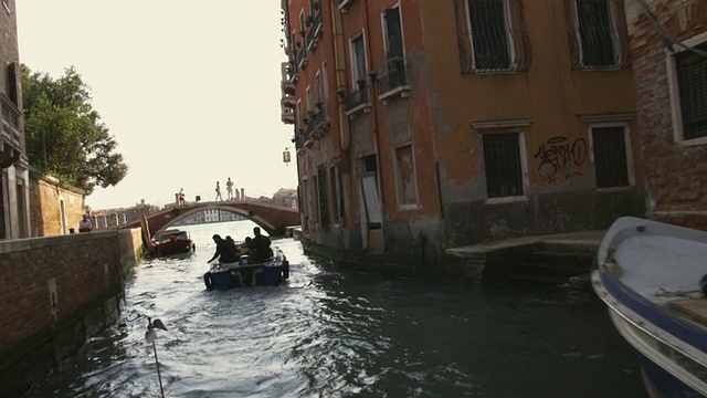 意大利威尼斯，一艘摩托艇驶过运河上的建筑物视频素材