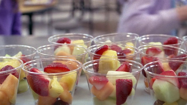 在缅因州的戈拉姆，孩子们在学校午餐队伍中拿起水果杯视频下载