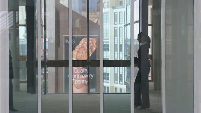 英国伦敦，穿过中庭，透过窗户看到办公室里的商务人士视频下载