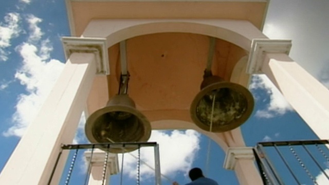 墨西哥普埃布拉教堂塔中鸣钟的人的低角度视频下载