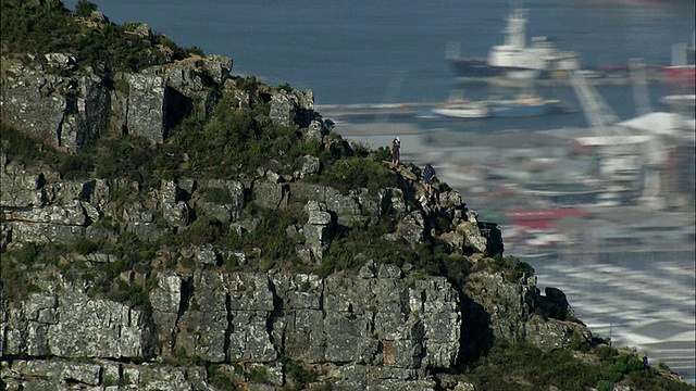游客从狮头上下来，背景是开普敦，西开普敦，南非视频下载