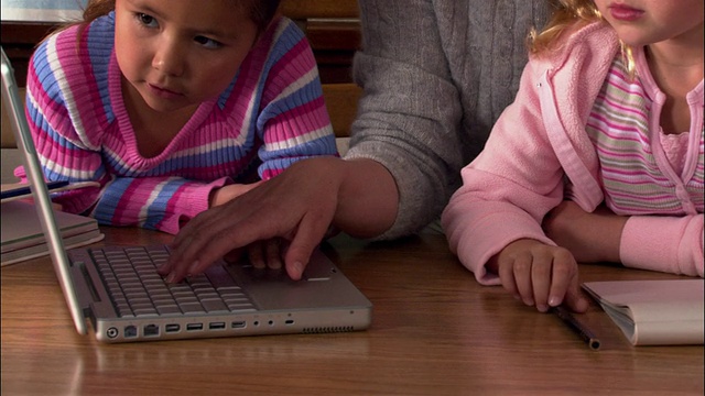 近距离的教师和学生使用笔记本电脑在教室视频下载