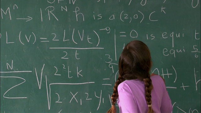 女孩在黑板上解数学题的中镜头后视图视频下载