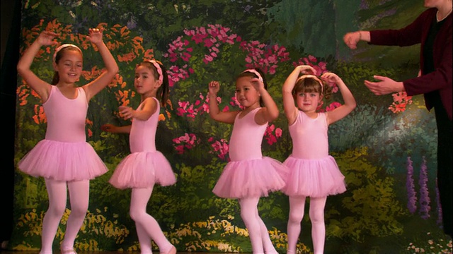 (广角镜头)四个穿着芭蕾舞裙的年轻女孩从老师面前走到舞台上，然后转着圈跳舞视频下载