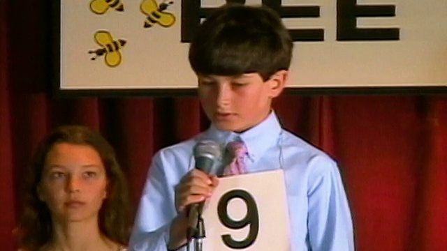 潘在拼字比赛中穿过坐在舞台上的选手，男孩走向麦克风拼字/洛杉矶，加利福尼亚视频下载