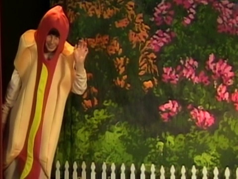 加州洛杉矶，一个穿着热狗服装的男孩在舞台边对着镜头挥手视频下载