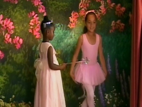 在加州洛杉矶的芭蕾舞演奏会上，穿着仙女服装的女孩和穿着粉色短裙的女孩在舞台上表演视频下载