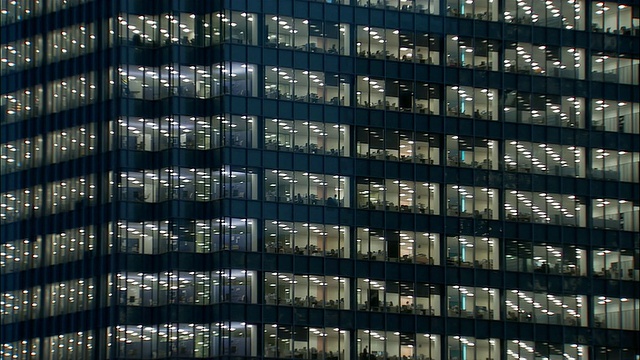 办公大楼的宽镜头窗户在晚上可以看到里面的人/伦敦视频下载