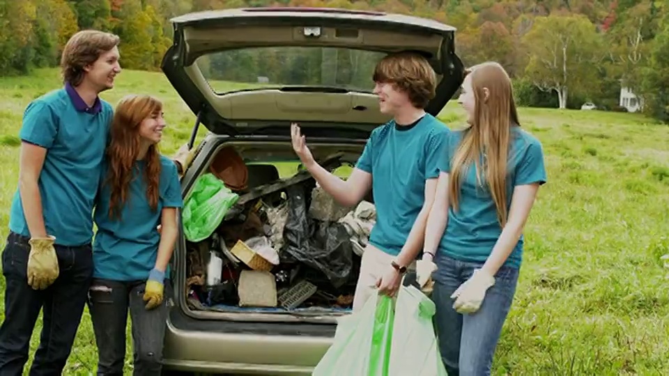 美国佛蒙特州多塞特，一群青少年站在装满垃圾的汽车旁，做着击掌的手势视频下载