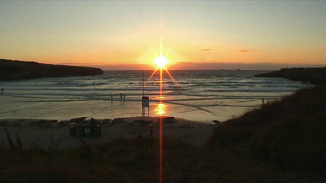 日落时海滩上冲浪者的剪影/康沃尔，英国视频素材