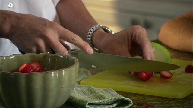 美国佛罗里达州杰克逊维尔市，一位妇女在厨房柜台上切草莓视频下载