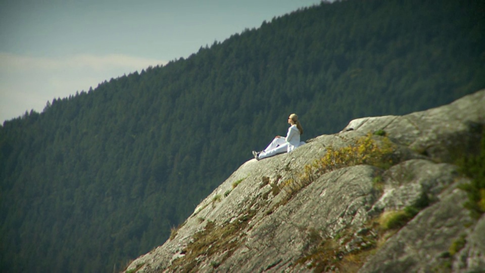 年轻女子坐在大岩石上俯瞰马蹄湾/惠斯勒，加拿大不列颠哥伦比亚省视频下载