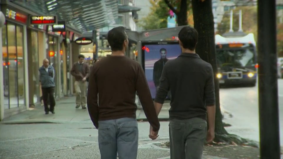 两名男子手牵着手走在加拿大不列颠哥伦比亚省温哥华的街道上视频下载