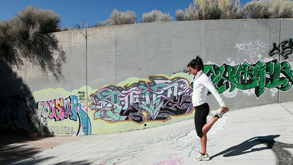 WS女跑步者在涂鸦墙前伸展/圣达菲，新墨西哥，美国视频下载