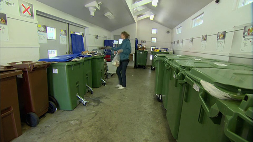 女子进入回收室，将垃圾分类到不同的容器中/瑞典马尔默视频下载