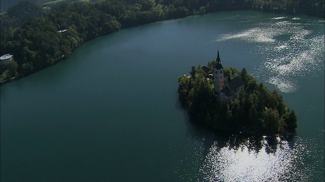 斯洛文尼亚小岛上圣母升天的朝圣教堂的空中湖视频下载
