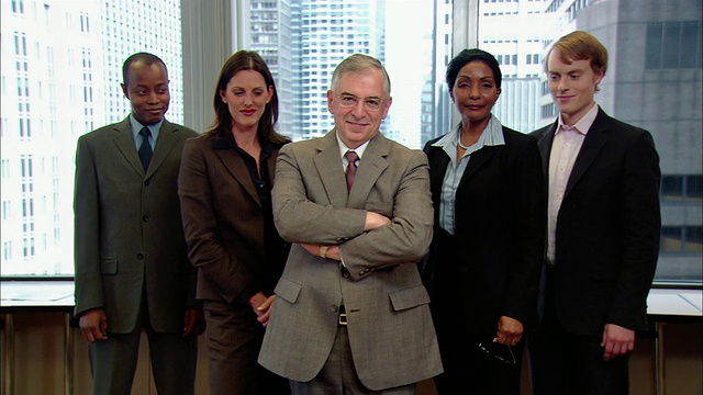 中景拍摄了五名办公室职员站成V字队形/老板抱着胳膊微笑/另外四个人抱着胳膊/纽约视频下载