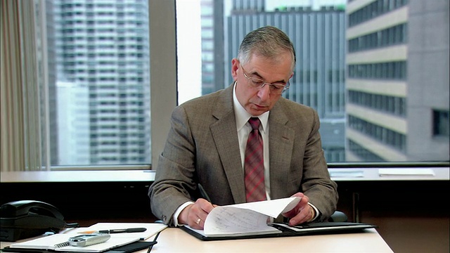 中景放大商人在书桌上写作/检查手表/人写作/纽约，纽约视频下载
