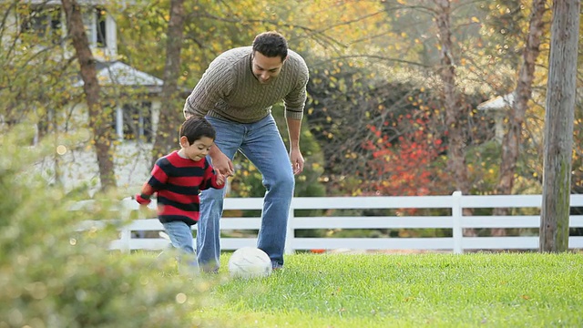 美国弗吉尼亚州里士满，父亲在后院教儿子(2-3)踢足球视频素材