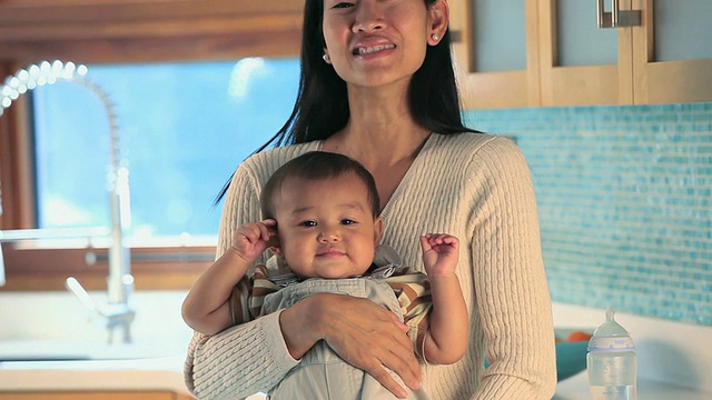 母亲抱着婴儿(6-11个月)在厨房/里士满，弗吉尼亚州，美国。视频素材