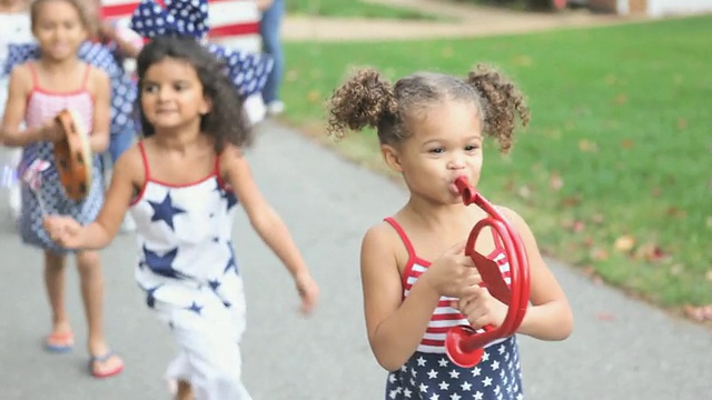一群儿童(4-7人)在美国弗吉尼亚州里士满的独立日游行中行走。视频素材