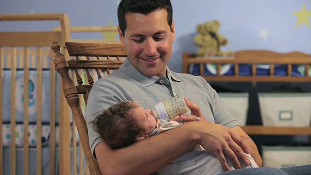 美国弗吉尼亚州里士满，父亲用奶瓶给2-5个月大的男婴喂奶。视频素材