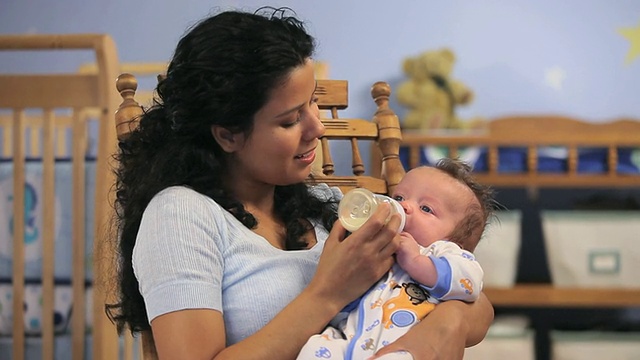 美国弗吉尼亚州里士满育婴室，母亲用奶瓶喂养2-5个月大的男婴。视频素材