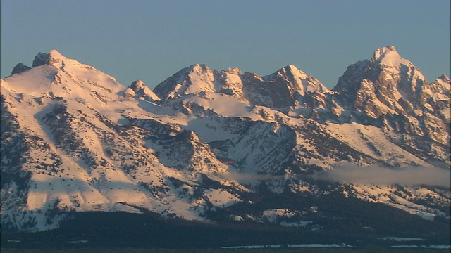 落基的，崎岖的和白雪覆盖的山峰在日落的粉红色的蒂顿山/大蒂顿国家公园，怀俄明州，美国视频素材