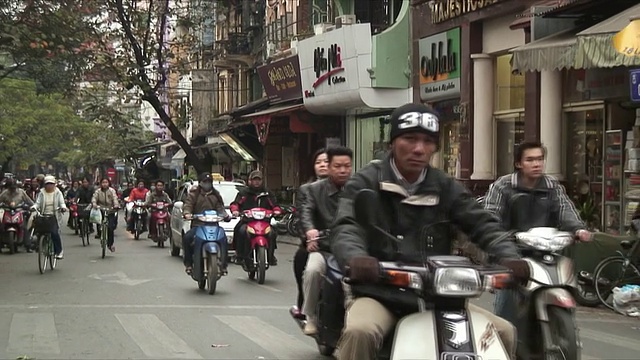 越南河内，人们在拥挤的街道上骑自行车和摩托车视频素材
