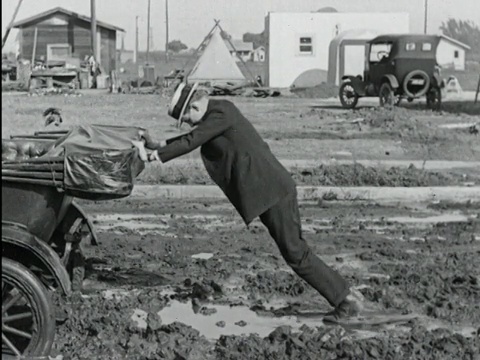 20世纪20年代B/W蒙太奇查理蔡斯推着车，在泥浆中跌倒/美国加州/音频视频下载