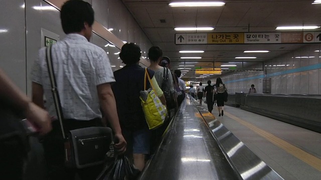 韩国首尔机场使用移动人行道的人的后视图视频素材