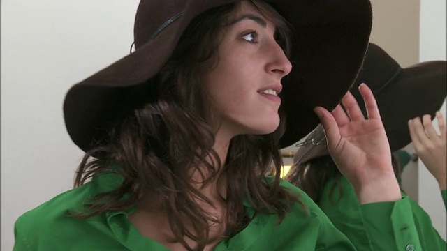 比利时布鲁塞尔，一名女子在服装店镜子前试帽子视频素材