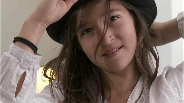比利时布鲁塞尔的一家服装店里，CU女孩(10-11)试帽子视频素材