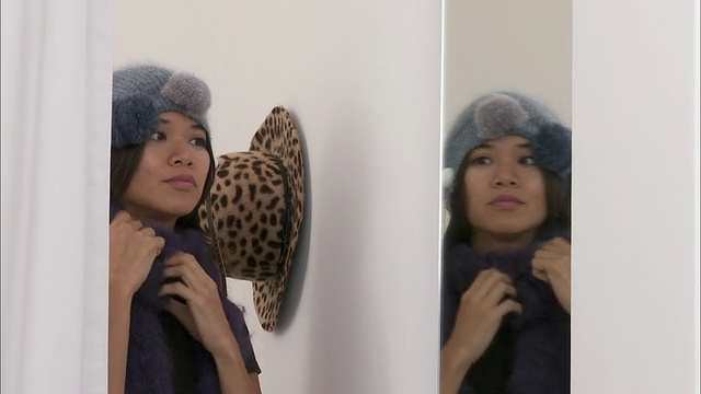 比利时布鲁塞尔，一名女子在试衣间试穿羊毛围巾和帽子视频素材