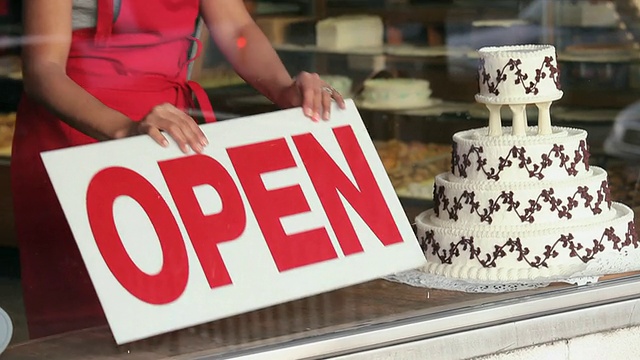 MS TU女面包师放置“开放”的标志在面包店的窗口/里士满，弗吉尼亚州，美国视频素材