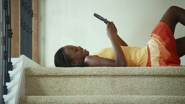 MS SHAKY LA Girl(8-9)躺在楼梯上发短信/ Bothell，华盛顿州，美国视频素材