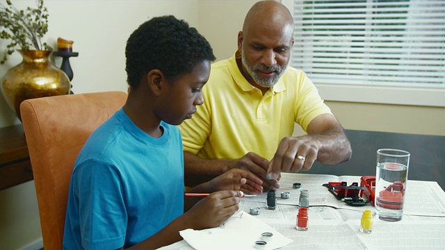 父亲和儿子(10-11)在餐桌上画模型汽车/ Bothell，华盛顿州，美国视频下载