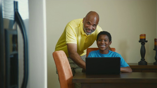 父亲和儿子(10-11)在餐厅使用笔记本电脑/ Bothell，华盛顿州，美国视频素材