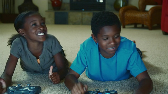 MS Children(8-11)躺在地毯上玩电子游戏/ Bothell，华盛顿州，美国视频下载