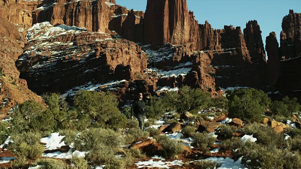 WS DS摄影师行走在沙漠附近的岩层/摩押，犹他州，美国视频素材