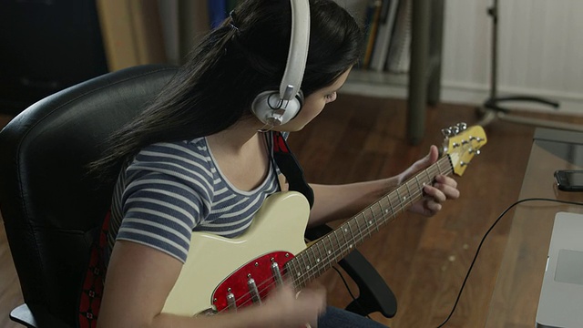 MS DS少女(16-17)戴耳机玩电吉他在家/ Orem，犹他州，美国视频下载